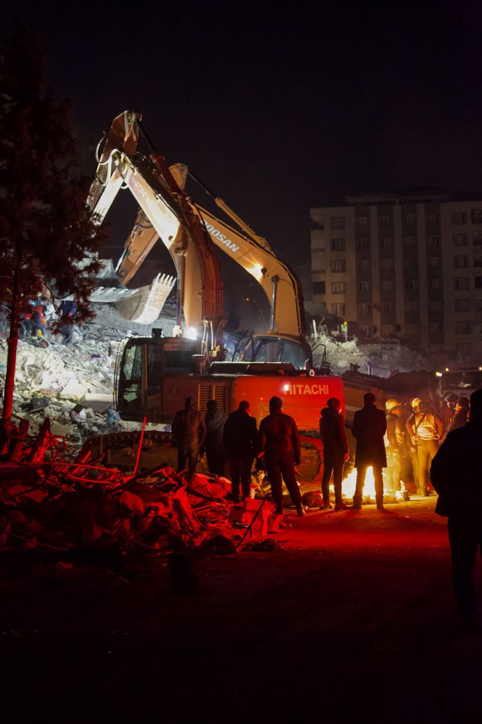 Crafting Captivating Headlines: Your awesome post title goes here Excavators work through the night at a construction site surrounded by debris and workers.