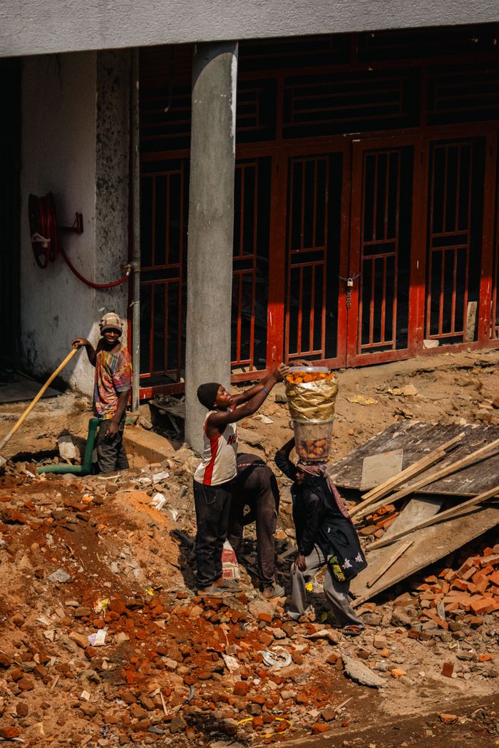 our-mission A group of construction workers engaged in manual labor on a city building site.